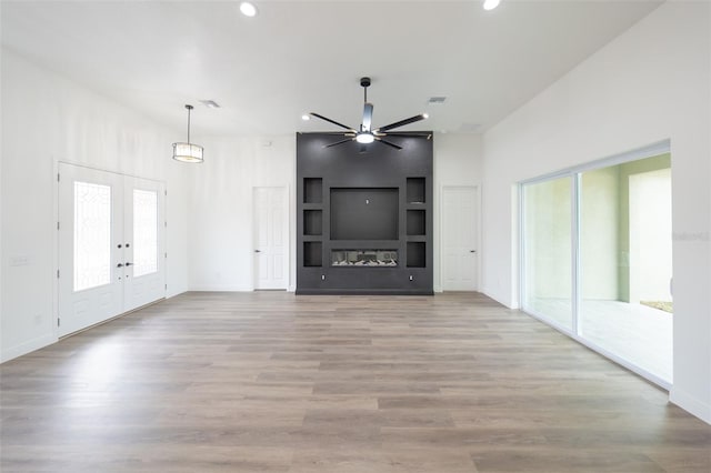 unfurnished living room featuring french doors, ceiling fan, and light hardwood / wood-style floors