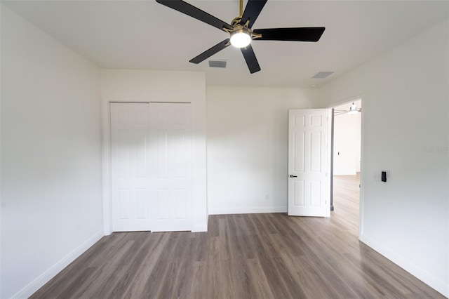 unfurnished bedroom featuring a closet, dark hardwood / wood-style floors, and ceiling fan