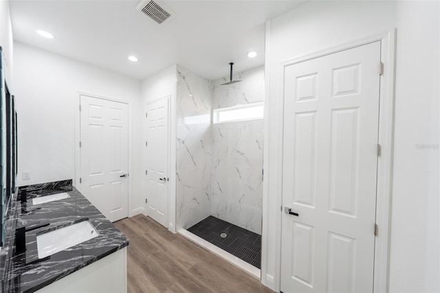 bathroom featuring a tile shower, hardwood / wood-style floors, and vanity