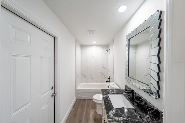 full bathroom featuring tiled shower / bath combo, vanity, hardwood / wood-style flooring, and toilet