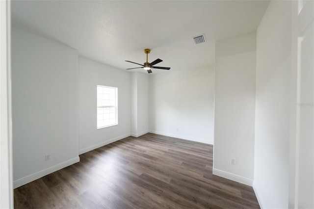 empty room with ceiling fan and dark hardwood / wood-style flooring