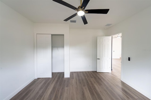 unfurnished bedroom with ceiling fan, dark hardwood / wood-style floors, and a closet