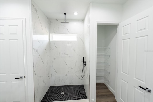 bathroom with hardwood / wood-style flooring and tiled shower