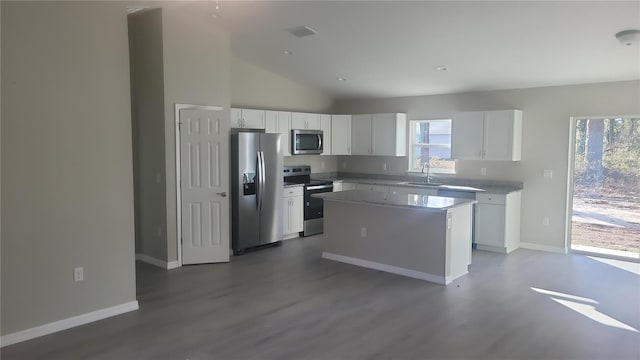 kitchen featuring sink, hardwood / wood-style flooring, appliances with stainless steel finishes, white cabinetry, and a center island