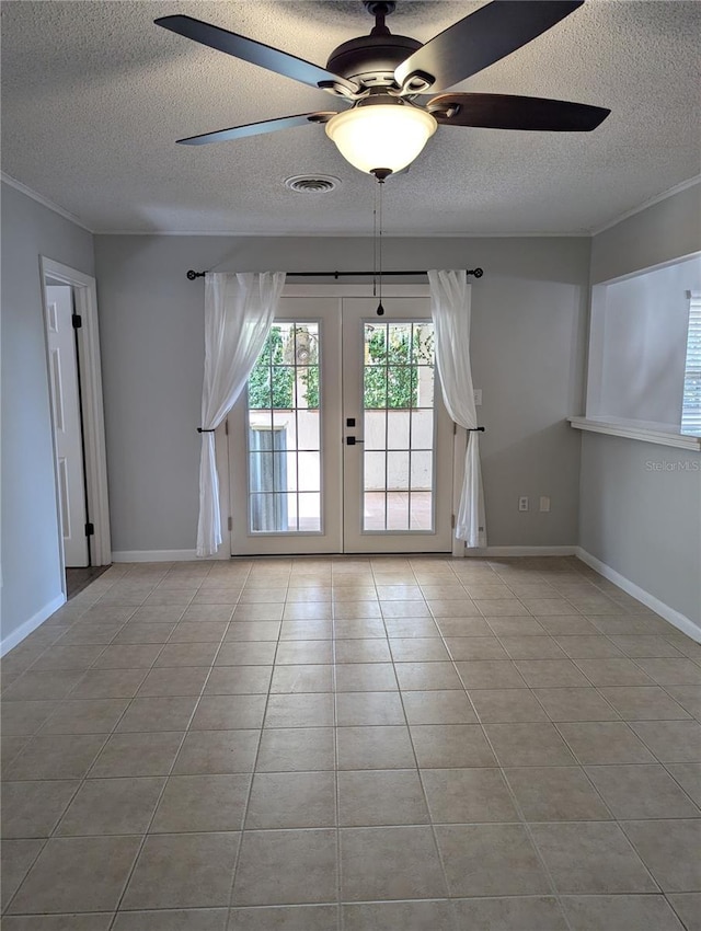 empty room with a textured ceiling, tile patterned flooring, visible vents, baseboards, and french doors