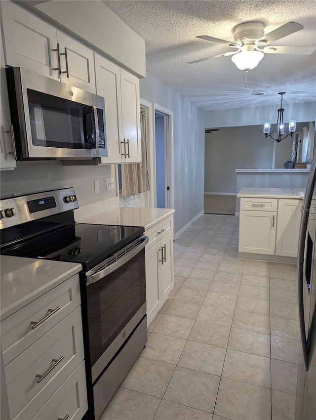 kitchen with light tile patterned floors, stainless steel appliances, light countertops, and white cabinets