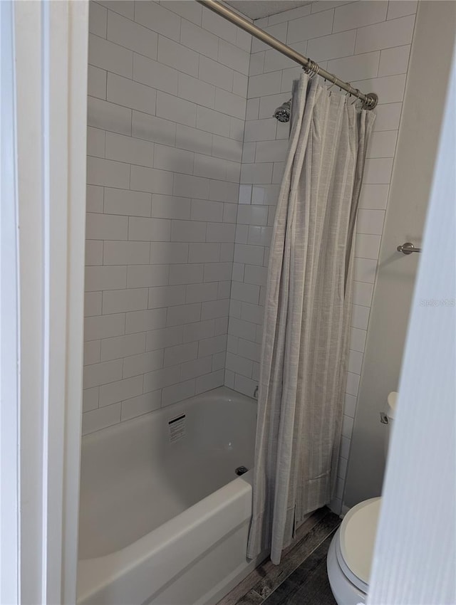 bathroom with shower / bath combination with curtain and toilet