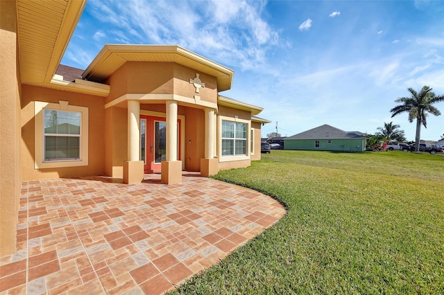 back of property with a patio and a lawn