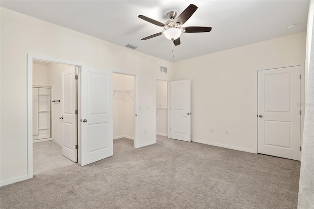 13818 NW 9th Rd, Newberry, FL 32669 - unfurnished bedroom with ensuite bathroom, a walk in closet, light colored carpet, ceiling fan, and a closet