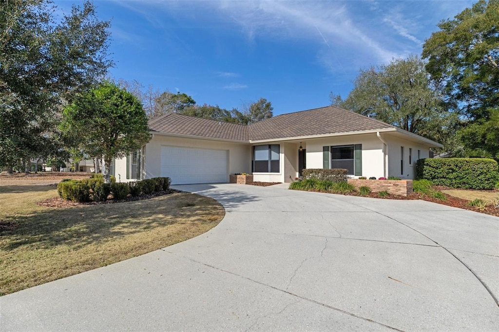 ranch-style home featuring a garage and a front yard