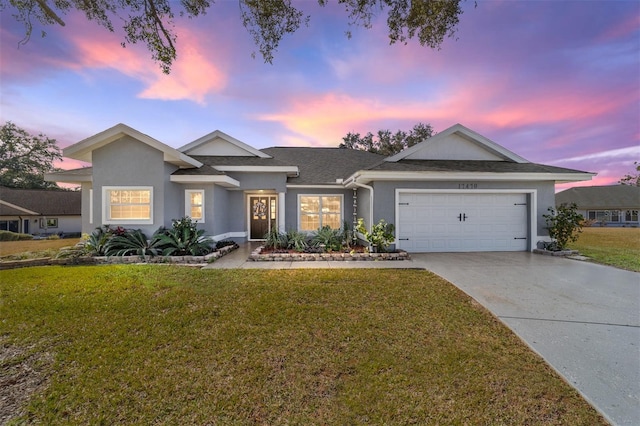 view of front of house featuring a garage and a lawn