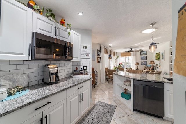 kitchen with white cabinetry, black dishwasher, backsplash, light stone counters, and a textured ceiling