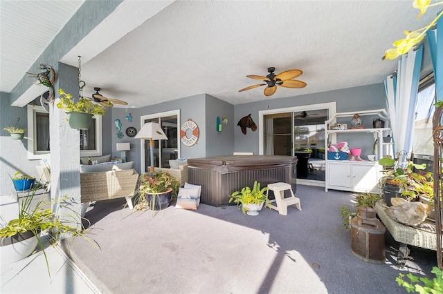 view of patio / terrace with ceiling fan, a hot tub, and an outdoor hangout area