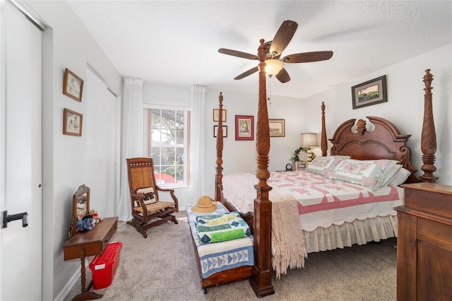 bedroom featuring ceiling fan, light colored carpet, and a textured ceiling