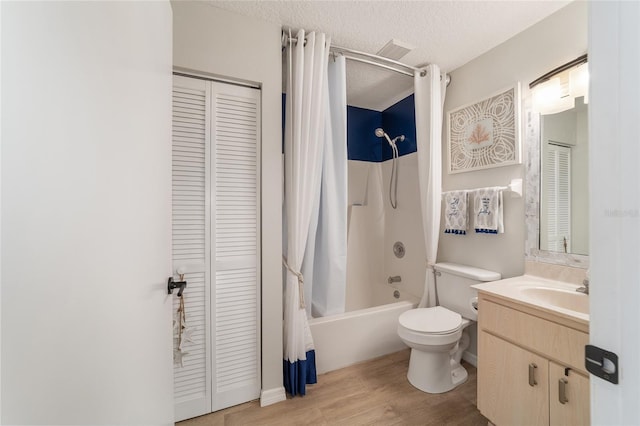 full bathroom featuring toilet, a textured ceiling, vanity, shower / bath combo, and hardwood / wood-style floors