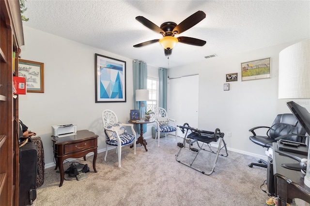 office featuring ceiling fan, light carpet, and a textured ceiling