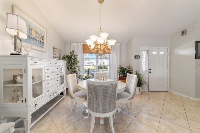 tiled dining room featuring vaulted ceiling and a chandelier