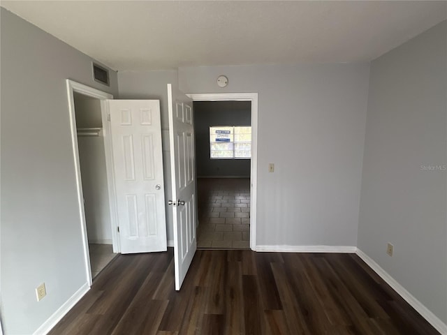 unfurnished bedroom with dark hardwood / wood-style floors