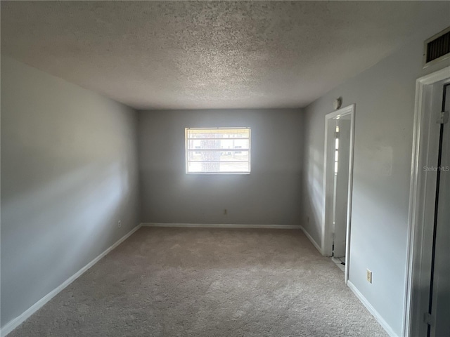 empty room featuring light carpet and a textured ceiling