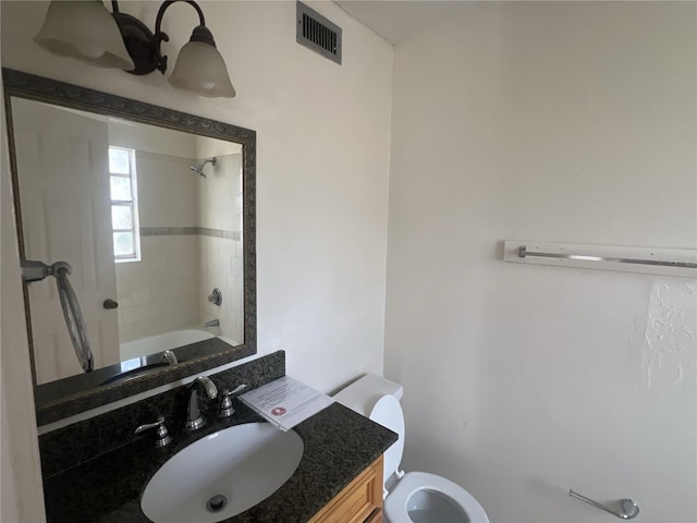 full bathroom featuring tiled shower / bath combo, vanity, and toilet