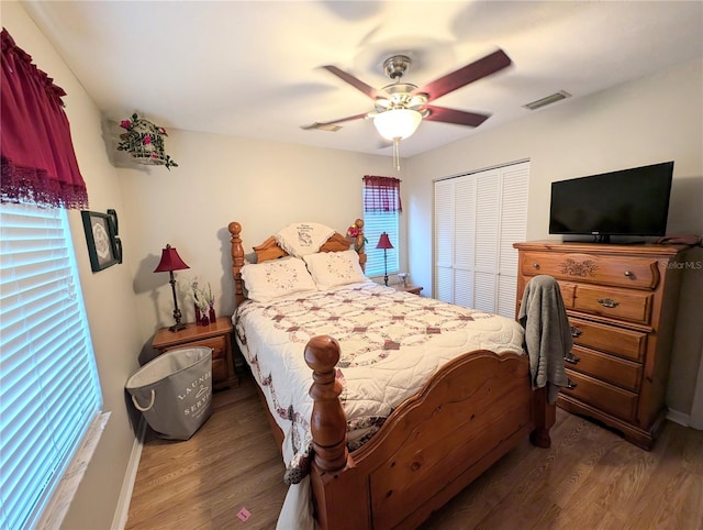 bedroom featuring dark wood-type flooring, a closet, and ceiling fan