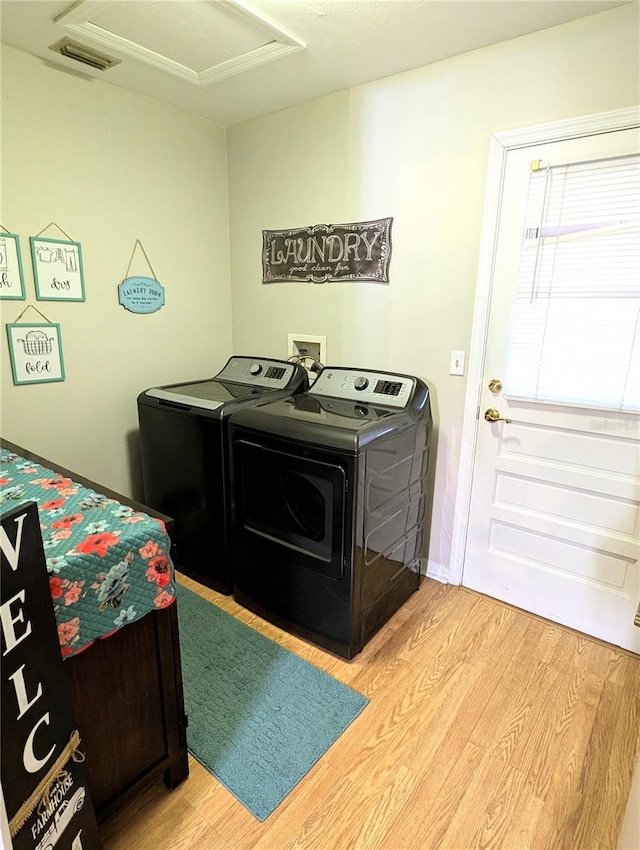 washroom with washer and clothes dryer and light hardwood / wood-style flooring