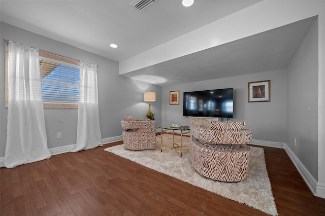 sitting room with dark wood-style flooring, visible vents, and baseboards