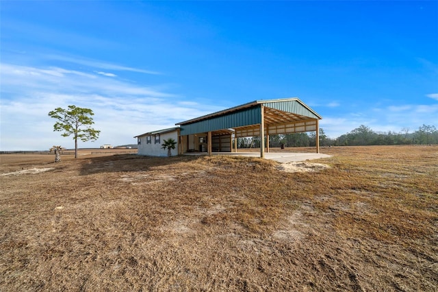 view of outdoor structure featuring a carport and a rural view