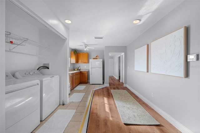 washroom with light tile patterned floors, laundry area, visible vents, baseboards, and independent washer and dryer