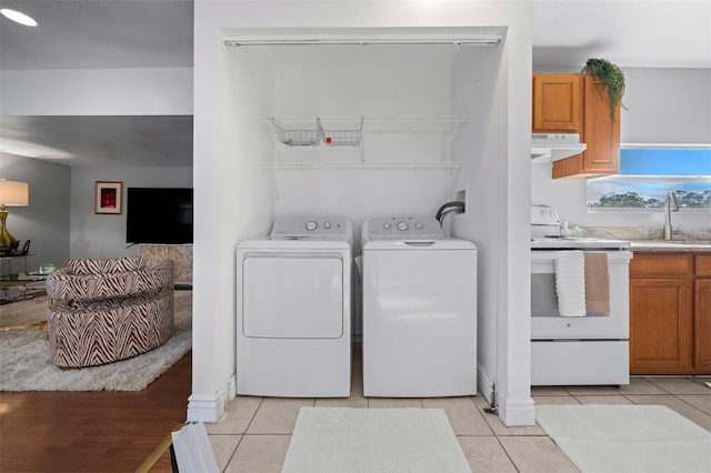 laundry room featuring laundry area, light tile patterned flooring, a sink, and washer and dryer