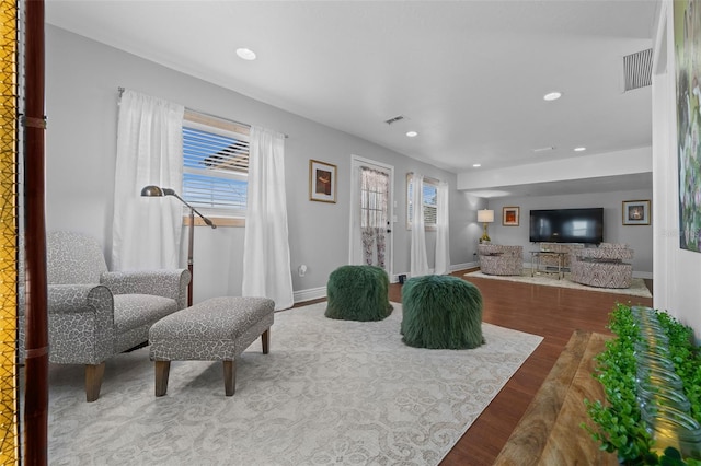 living area with recessed lighting, visible vents, baseboards, and wood finished floors