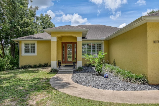 property entrance with a lawn