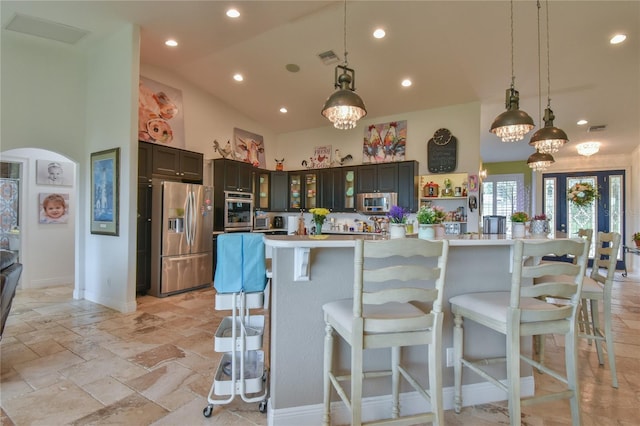 kitchen featuring a large island, pendant lighting, stainless steel appliances, and a kitchen bar