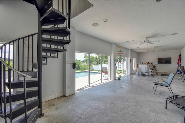 interior space with concrete flooring, ceiling fan, and a textured ceiling