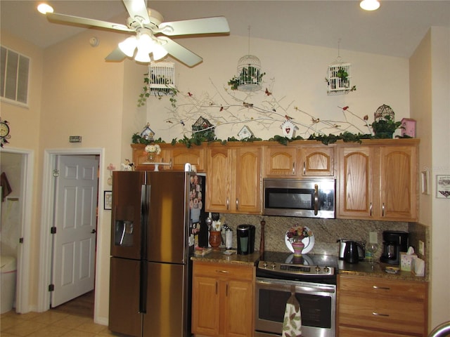 kitchen featuring ceiling fan, tasteful backsplash, stainless steel appliances, and dark stone countertops