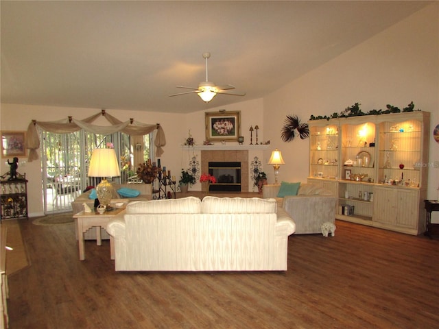 living room with ceiling fan, lofted ceiling, dark hardwood / wood-style floors, and a tiled fireplace