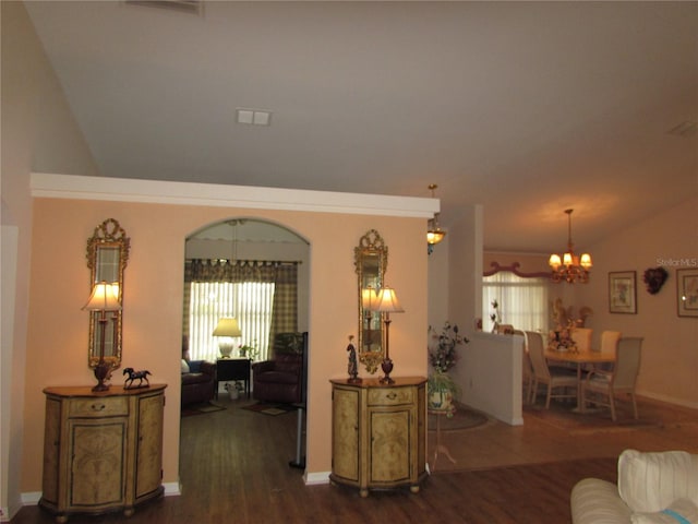 living room with lofted ceiling, dark hardwood / wood-style flooring, and an inviting chandelier