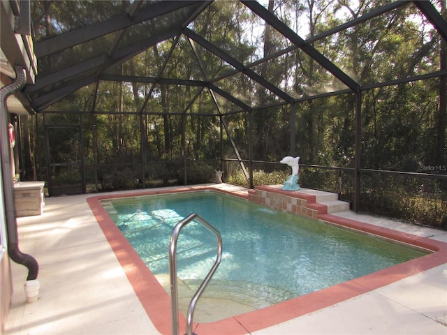 view of swimming pool with a patio, a lanai, and pool water feature