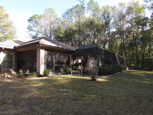 back of property with a lawn and glass enclosure