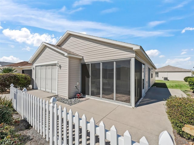 view of front of property with a garage and a sunroom