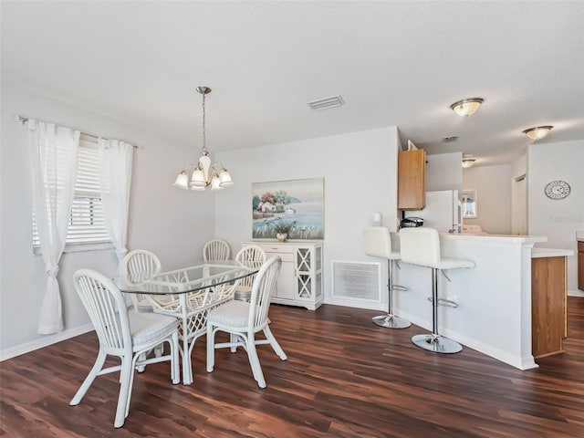 dining room with an inviting chandelier and dark hardwood / wood-style flooring