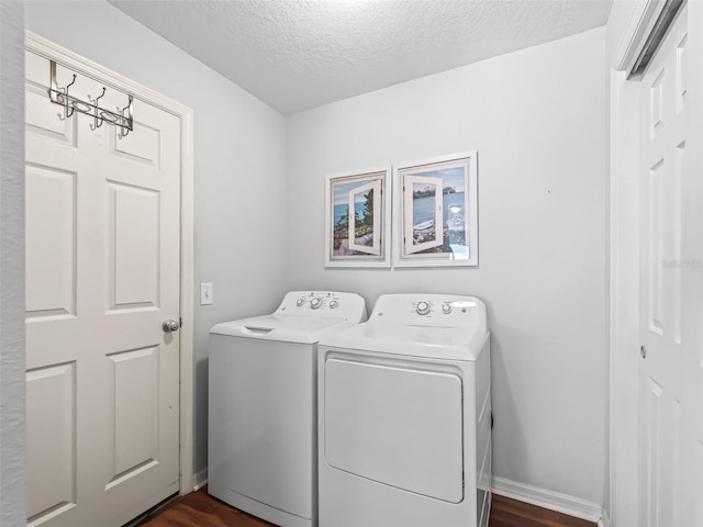 laundry room featuring dark hardwood / wood-style flooring, washer and clothes dryer, and a textured ceiling