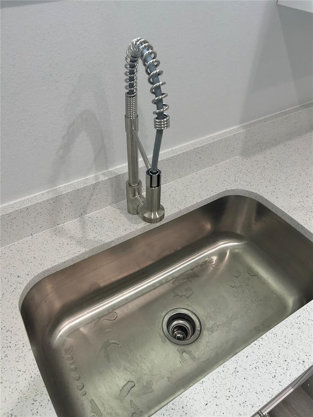 room details with light stone counters and a sink
