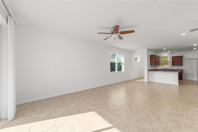 unfurnished living room with sink and ceiling fan