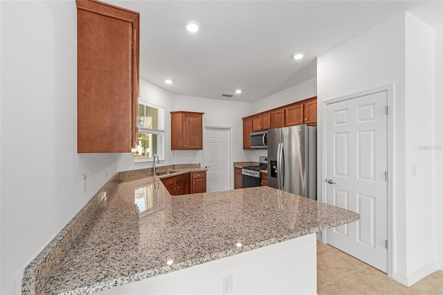 kitchen featuring light tile patterned flooring, sink, light stone counters, appliances with stainless steel finishes, and kitchen peninsula