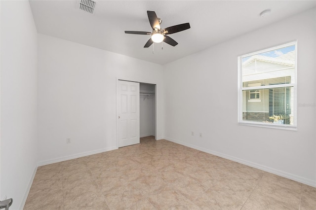 unfurnished bedroom with ceiling fan and a closet