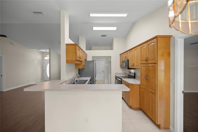 kitchen with lofted ceiling, sink, appliances with stainless steel finishes, light tile patterned flooring, and kitchen peninsula