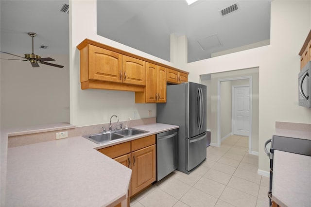 kitchen with light tile patterned flooring, ceiling fan, appliances with stainless steel finishes, and sink