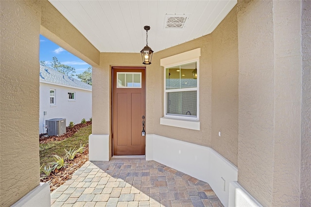 view of exterior entry featuring central AC unit