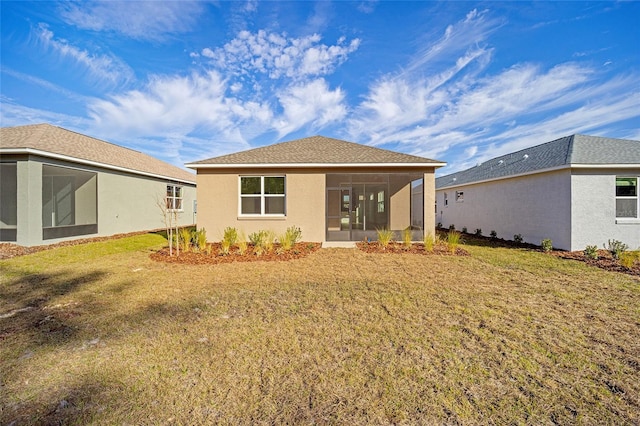 back of house featuring a sunroom and a lawn